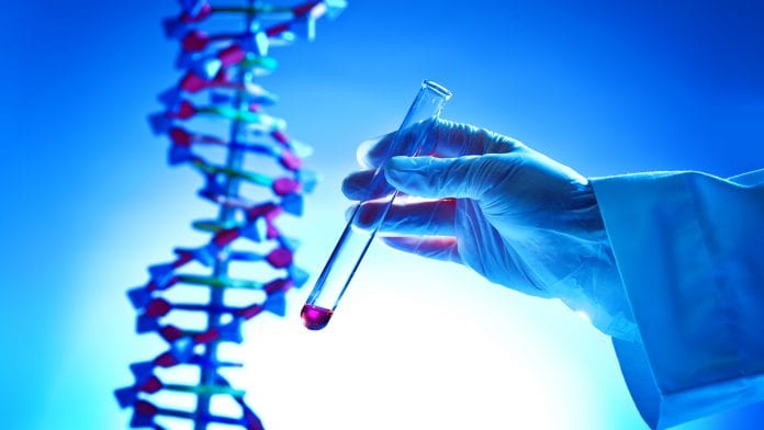 doctor holding test tube in front of DNA strand