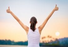 Is exercise the new prescription drug? Experts say yes Young woman with arms in the air giving thumbs up.