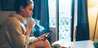 girl vaping at home on phone