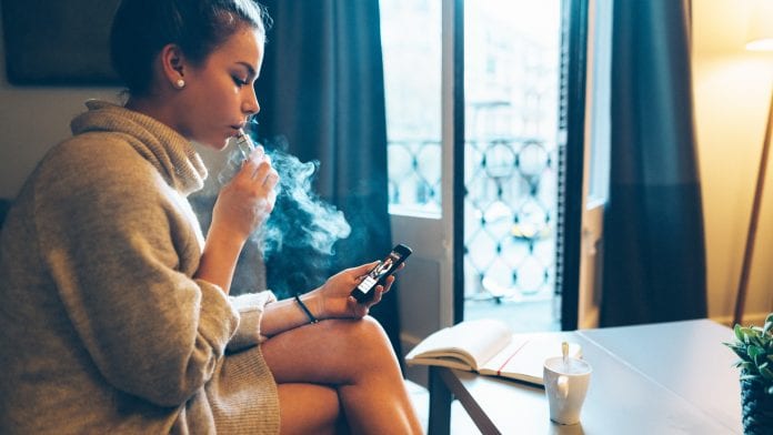 girl vaping at home on phone