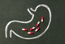 drawing of gut on chalk board with pills in the middle