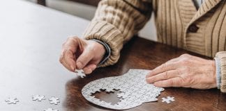 Cropped view of senior man playing with puzzles