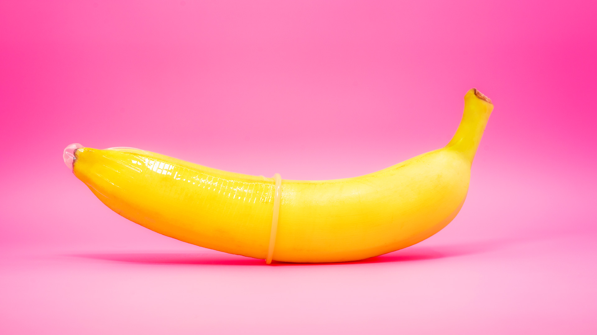 Transparent condom placed on banana. concept of sexual protection