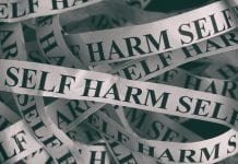 Crumpled paper pieces with words Self Harm stock photo