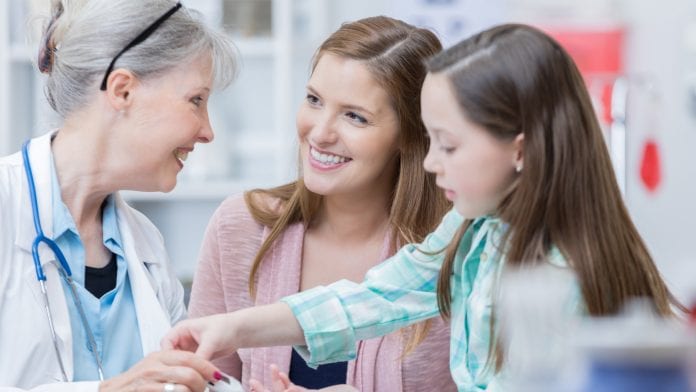 doctors showing insulin pen to child and mother