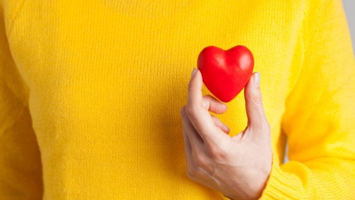 Young woman holding red heart, health insurance, donation, love concept