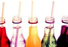 open glass bottles of soft drink with straws