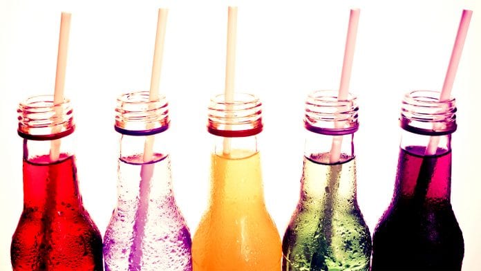 open glass bottles of soft drink with straws