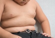 The size of stomach of children with overweight on grey background