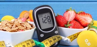 Glucometer with result of measurement sugar level, healthy food, dumbbells for fitness and tape measure, concept of diabetes, slimming, healthy lifestyle