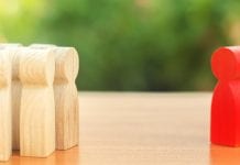 Uncovering bias and stereotyping when recruiting patients for clinical trials Red figurine of a man stands aside from the crowd of people. Asociality, sociopathy. Rejected from society, lonely. Infected, fear and misunderstanding. Development of leadership and social qualities.