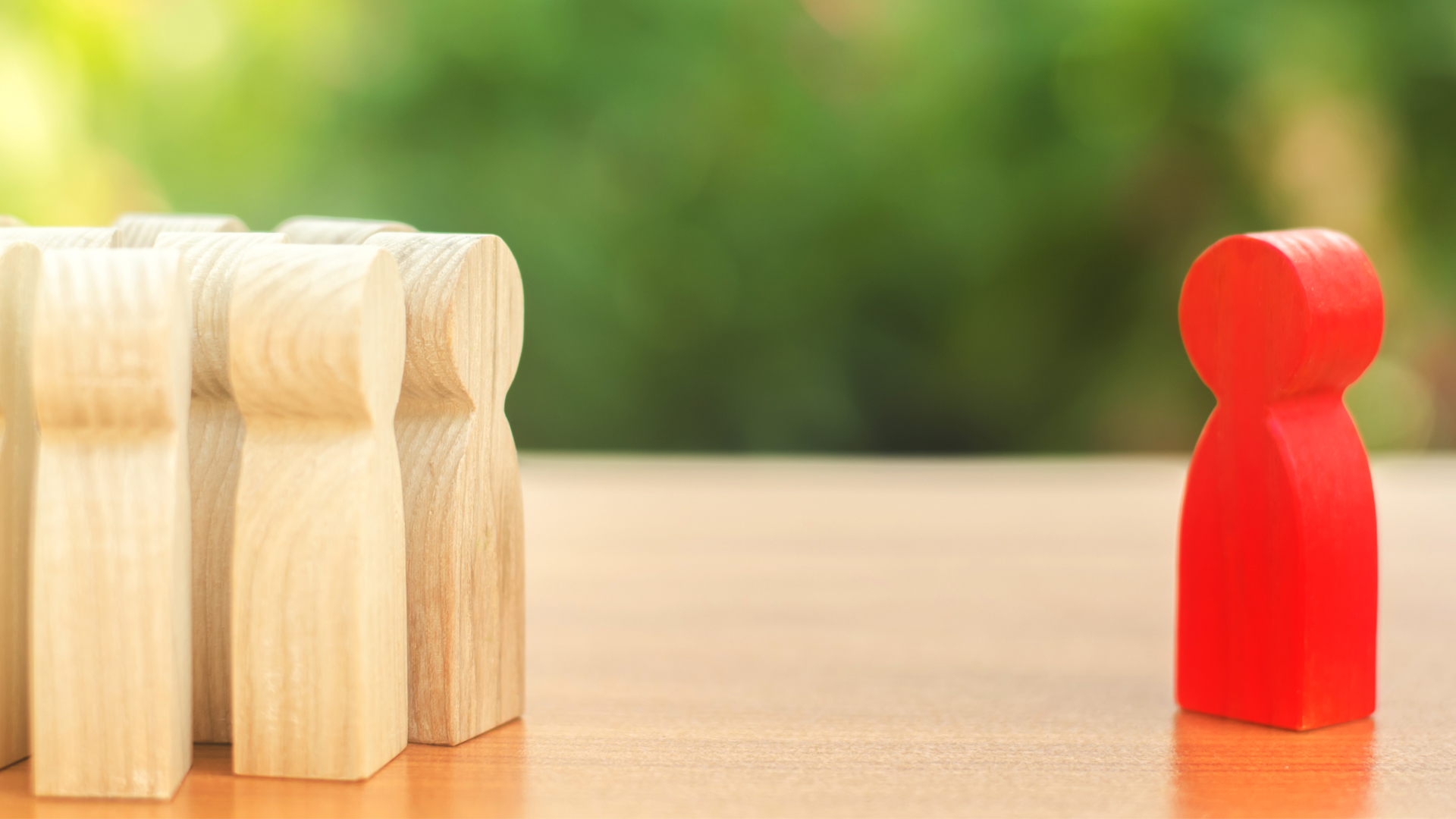 Red figurine of a man stands aside from the crowd of people. Asociality, sociopathy. Rejected from society, lonely. Infected, fear and misunderstanding. Development of leadership and social qualities.