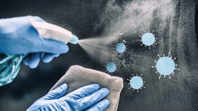 Cleaning home table disinfecting spray spraying on surface to sanitize COVID-19 prevention sanitizing for aerosol droplets. Coronavirus sanitize protection. Panoramic banner disinfection