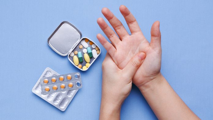 Woman hand with joint pain gout medication