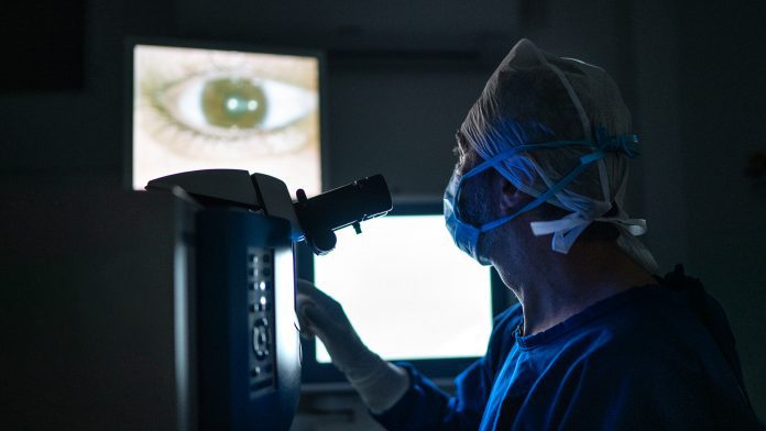 Doctor doing an exam or surgery, looking at images in monitor glaucoma treatment