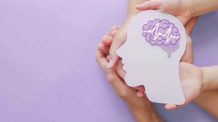 Adult and child hands holding encephalography brain paper cutout,autism, Stroke, Epilepsy and alzheimer awareness, seizure disorder, stroke, ADHD, world mental health day concept dementia care