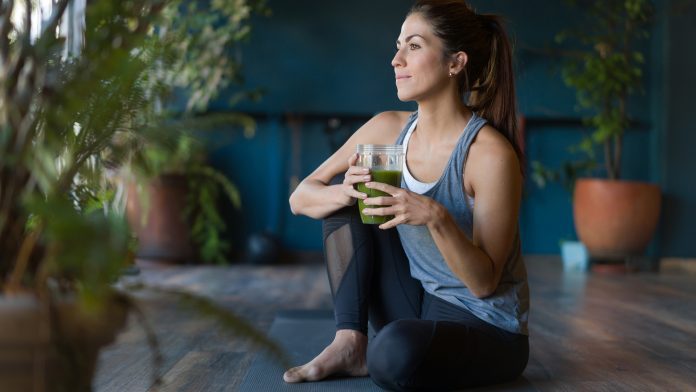 Fit woman drinking a green detox smoothie at the gym skin conditions