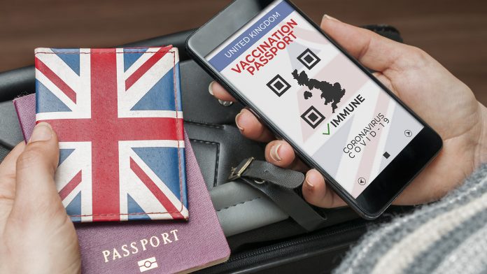 Uk vaccination passport concept: woman check the uk vaccination passport on her smartphone quarantine rules