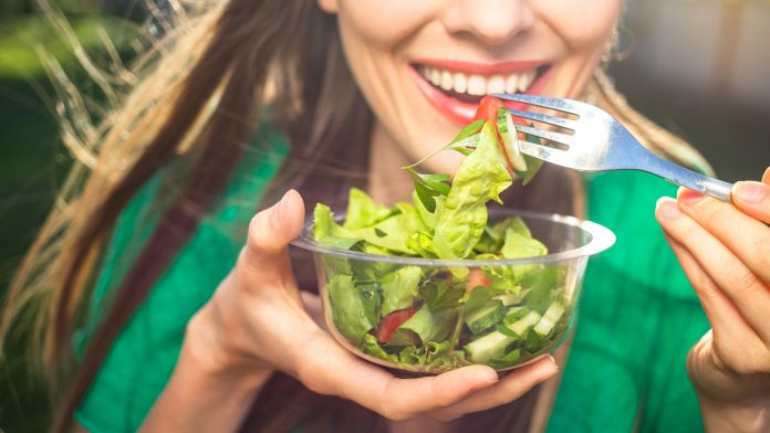 Woman eating healthy salad cardiovascular disease risk