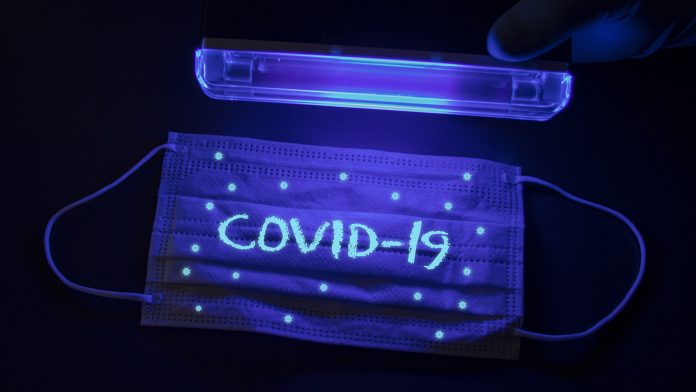 Medical mask Covid-19 under ultraviolet light UV LED lights