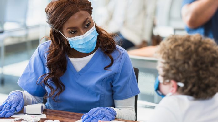 Nurse listens to patient COVID vaccine side effects