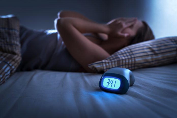 Sleepless woman suffering from insomnia, sleep apnea or stress. Tired and exhausted lady. Headache or migraine. Awake in the middle of the night. Frustrated person with problem. Alarm clock. major adverse cardiovascular events