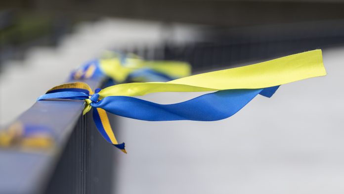 Ribbons in the colors of the national flag of Ukraine are tied to the handrail. war in Ukraine