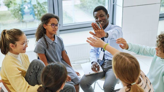 High,Angle,View,Of,Teen,High,Five,With,Therapist,While